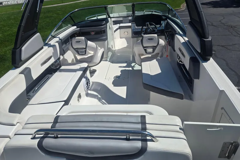 Slide: The Image of 2018 Chaparral 267 SSX boat interior with white seating and modern dashboard. - 10