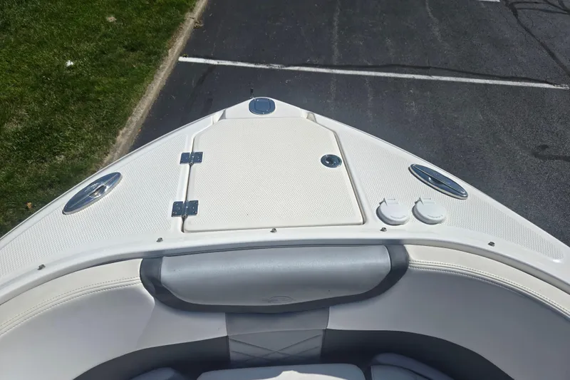 Slide: The Image of 2018 Chaparral 267 SSX boat bow with white seating and storage compartment. - 18