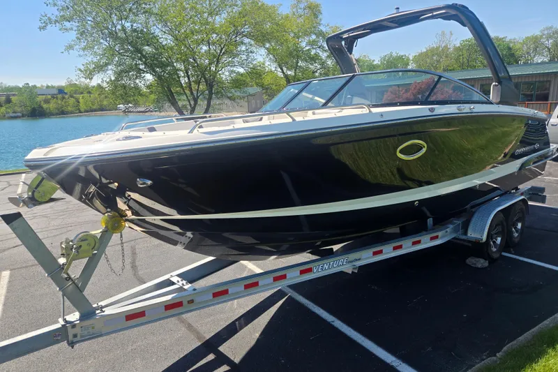 Slide: The Image of 2018 Chaparral 267 SSX boat on trailer, parked near a scenic lake. - 8