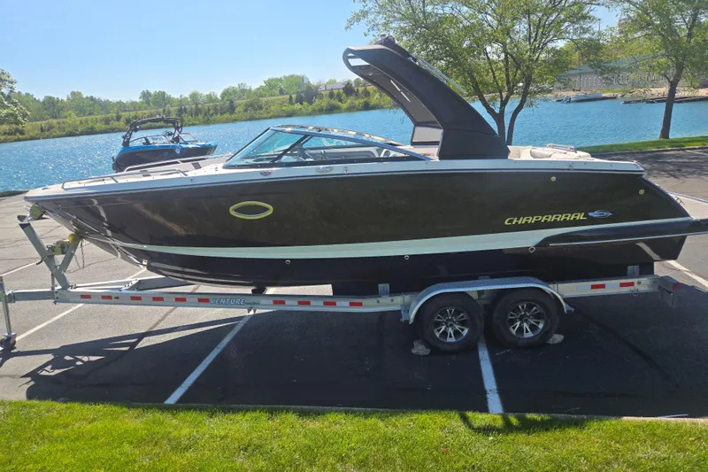 Slide: The Image of 2018 Chaparral 267 SSX boat on trailer by a scenic lake. - 9