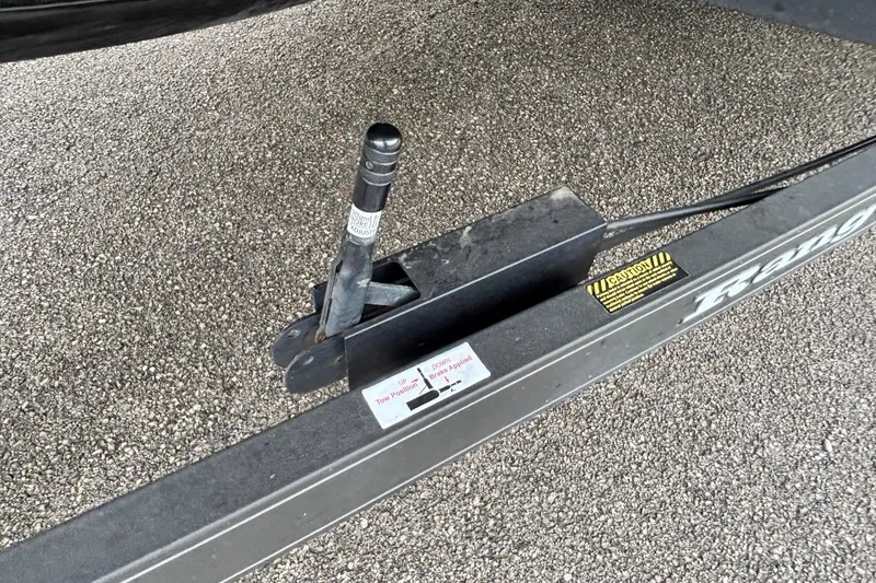 Slide: The Image of Trailer hitch mechanism on a 2019 Ranger Z521L boat trailer, parked on gravel. - 4