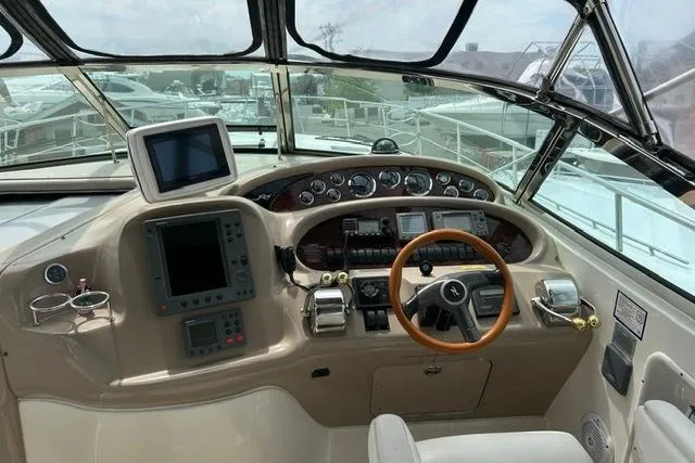 Slide: The Image of Cockpit of 2001 Sea Ray 38 Sundancer with navigation equipment and steering wheel. - 2
