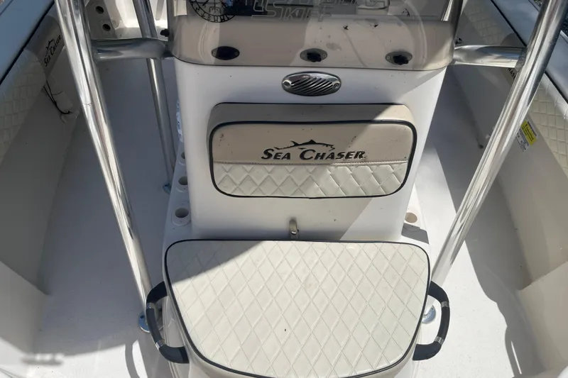 Slide: The Image of 2021 Sea Chaser 21 LX boat interior with cushioned seating and console details. - 9