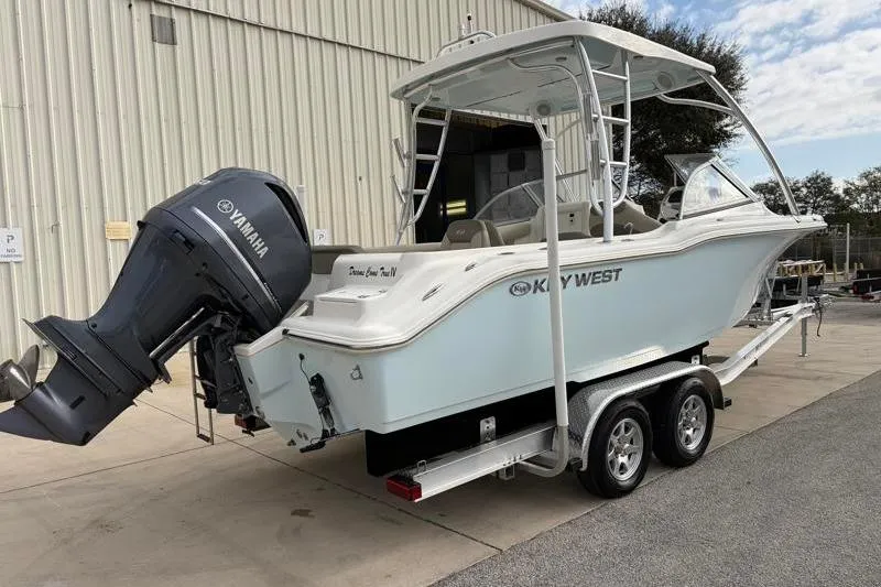 Slide: The Image of 2024 Key West 239 DFS boat on trailer with Yamaha outboard motor, parked outdoors. - 2