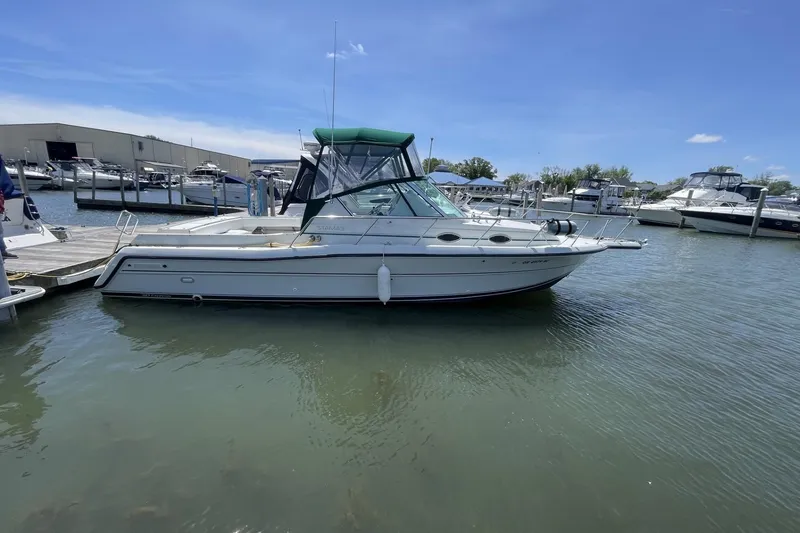 The Image of 1997 Stamas 310 Express boat docked at marina under clear blue sky. - 0