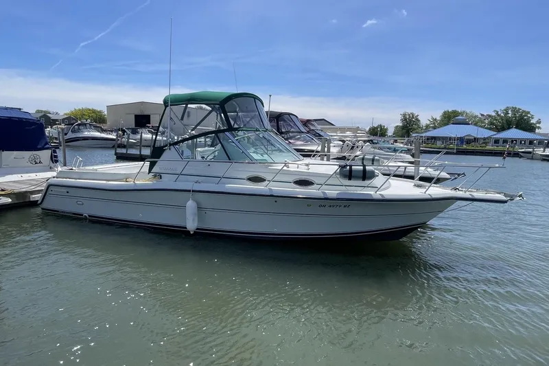 Slide: The Image of 1997 Stamas 310 Express boat docked in a marina under a clear blue sky. - 1