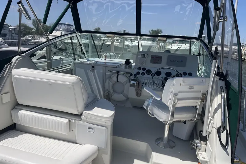 Slide: The Image of 1997 Stamas 310 Express boat cockpit with white seating and Garmin navigation system. - 11