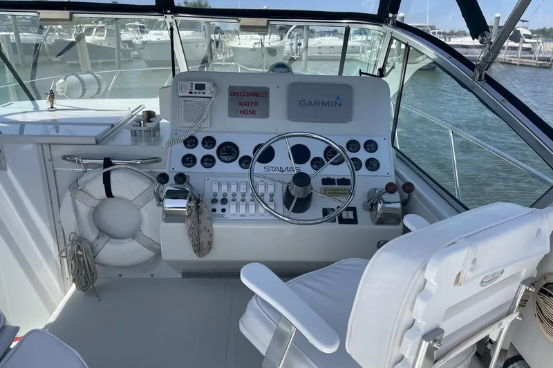 Slide: The Image of 1997 Stamas 310 Express boat cockpit with steering wheel, gauges, and Garmin navigation system. - 15