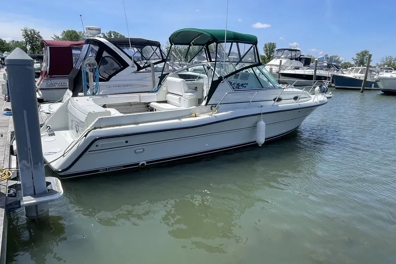 Slide: The Image of 1997 Stamas 310 Express boat docked in a marina under a clear blue sky. - 2