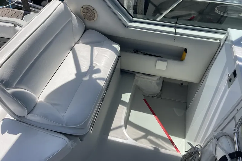 Slide: The Image of 1997 Stamas 310 Express boat interior with white seating and storage compartment. - 22