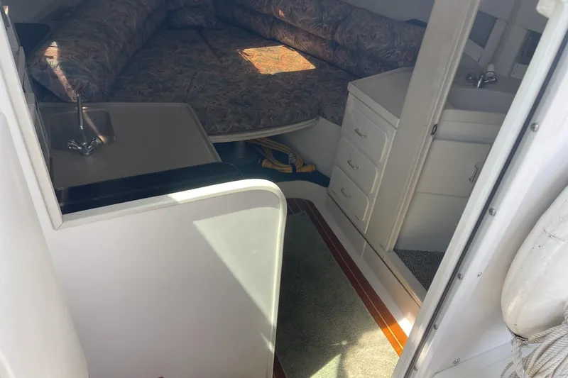 Slide: The Image of Interior of a 1997 Stamas 310 Express boat with cozy seating and compact kitchenette. - 25