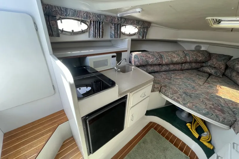 Slide: The Image of Interior of 1997 Stamas 310 Express boat with kitchenette and cozy seating area. - 28