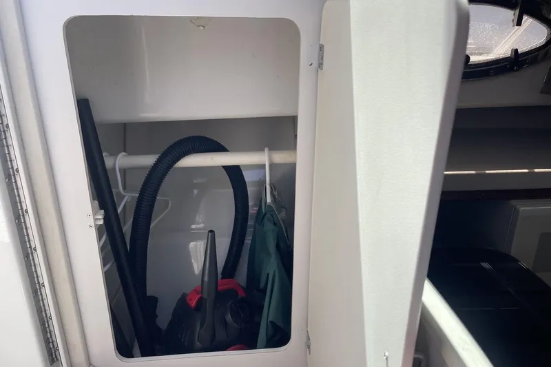 Slide: The Image of Storage compartment inside a 1997 Stamas 310 Express boat, containing cleaning equipment. - 29