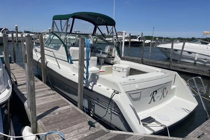 Slide: The Image of 1997 Stamas 310 Express boat docked at marina under clear blue sky. - 3