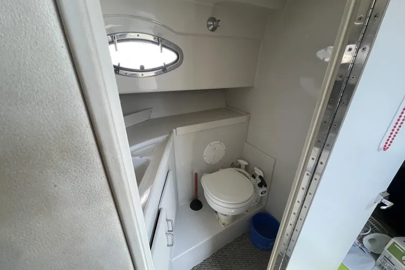 Slide: The Image of 1997 Stamas 310 Express boat bathroom interior with toilet and porthole window. - 32
