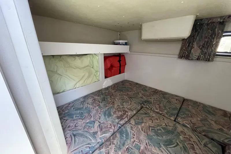 Slide: The Image of Interior cabin of 1997 Stamas 310 Express boat with patterned cushions and storage. - 36