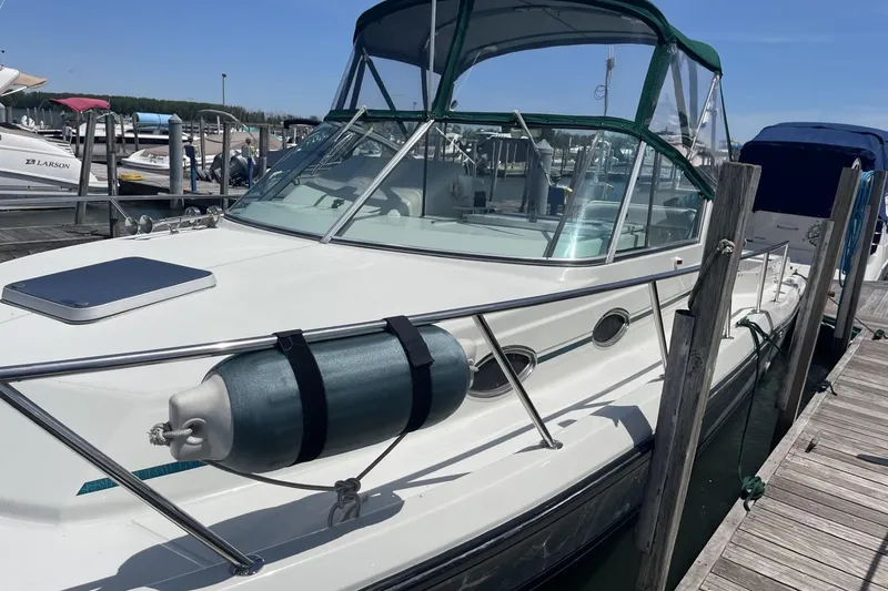 Slide: The Image of 1997 Stamas 310 Express boat docked at marina, featuring sleek design and green canopy. - 4
