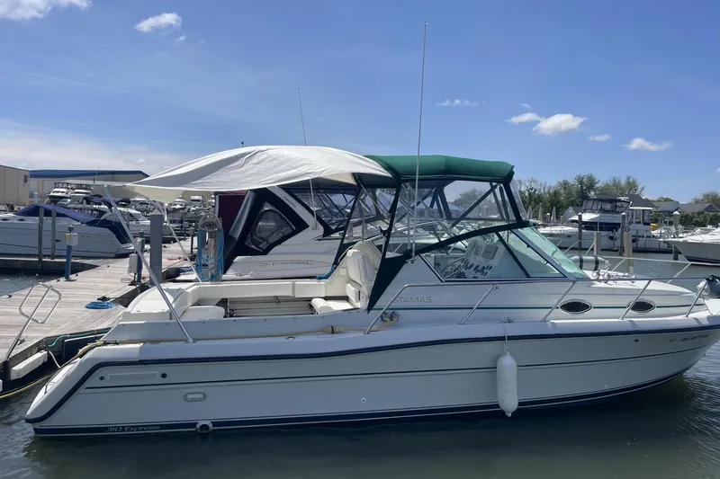 Slide: The Image of 1997 Stamas 310 Express boat docked at marina under clear blue sky. - 43