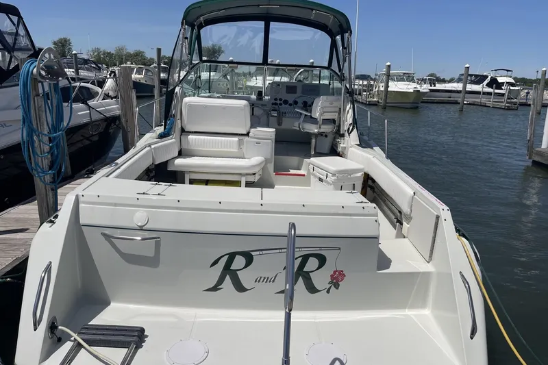 Slide: The Image of 1997 Stamas 310 Express boat docked at marina, featuring spacious seating and helm. - 5