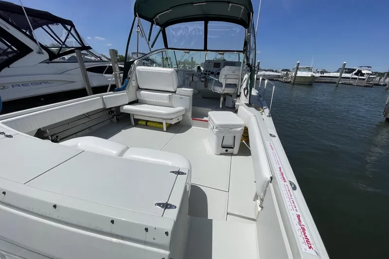Slide: The Image of 1997 Stamas 310 Express boat docked, featuring spacious seating and open deck layout. - 6