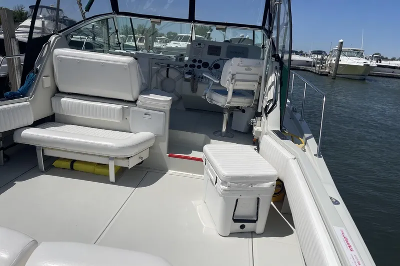Slide: The Image of 1997 Stamas 310 Express boat interior with seating and helm, docked at marina. - 7