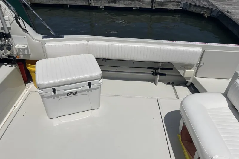 Slide: The Image of 1997 Stamas 310 Express boat interior with white seating and Yeti cooler. - 9