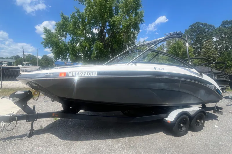 The Image of 2014 Yamaha Boats AR240 HO on trailer, parked outdoors under a clear blue sky. - 0