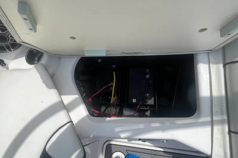 Slide: The Image of 2014 Yamaha AR240 HO boat battery compartment with wiring and storage area. - 12