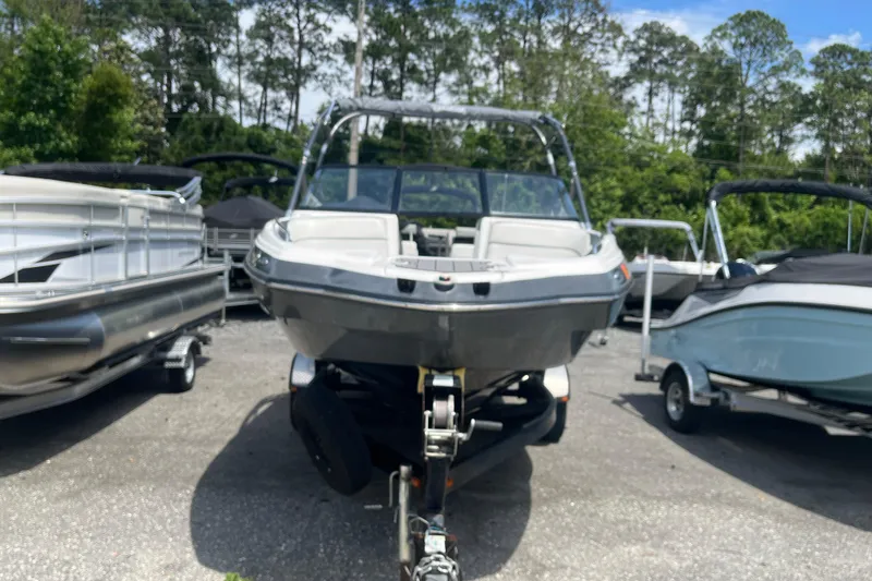 Slide: The Image of 2014 Yamaha Boats AR240 HO on trailer, surrounded by other boats, in outdoor setting. - 2