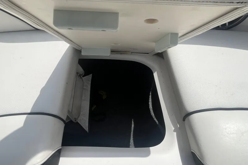 Slide: The Image of 2014 Yamaha Boats AR240 HO interior storage compartment with white seating. - 23