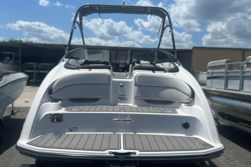 Slide: The Image of 2014 Yamaha Boats AR240 HO, rear view, showcasing swim platform and seating under a cloudy sky. - 3