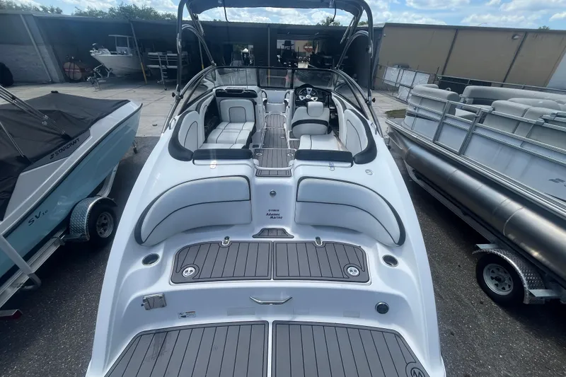 Slide: The Image of 2014 Yamaha Boats AR240 HO with sleek design and spacious seating in a marina setting. - 5
