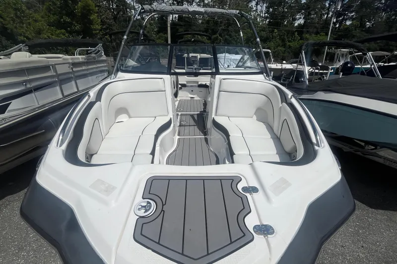 Slide: The Image of 2014 Yamaha Boats AR240 HO with spacious seating and sleek design in a marina setting. - 6