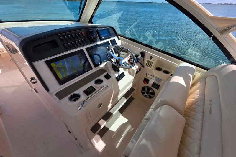Slide: The Image of Cockpit of 2019 Grady-White Freedom 375 boat with advanced navigation controls and luxurious seating. - 16