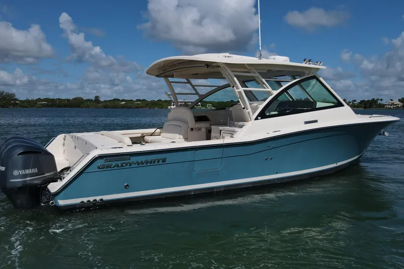 Slide: The Image of 2019 Grady-White Freedom 375 boat on water, featuring Yamaha engines, under a blue sky. - 2