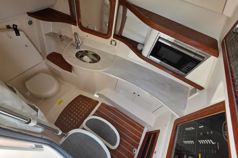 Slide: The Image of 2019 Grady-White Freedom 375 cabin interior with sink, microwave, and toilet. - 24