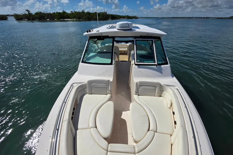 Slide: The Image of 2019 Grady-White Freedom 375 boat on calm water, featuring spacious seating and Garmin equipment. - 22