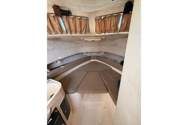 Slide: The Image of 1993 Grady-White Marlin 300 cabin interior with cushioned seating and compact design. - 30