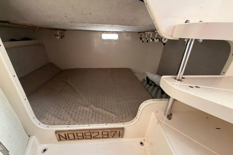 Slide: The Image of 1993 Grady-White Marlin 300 cabin interior with bed and storage shelves. - 32