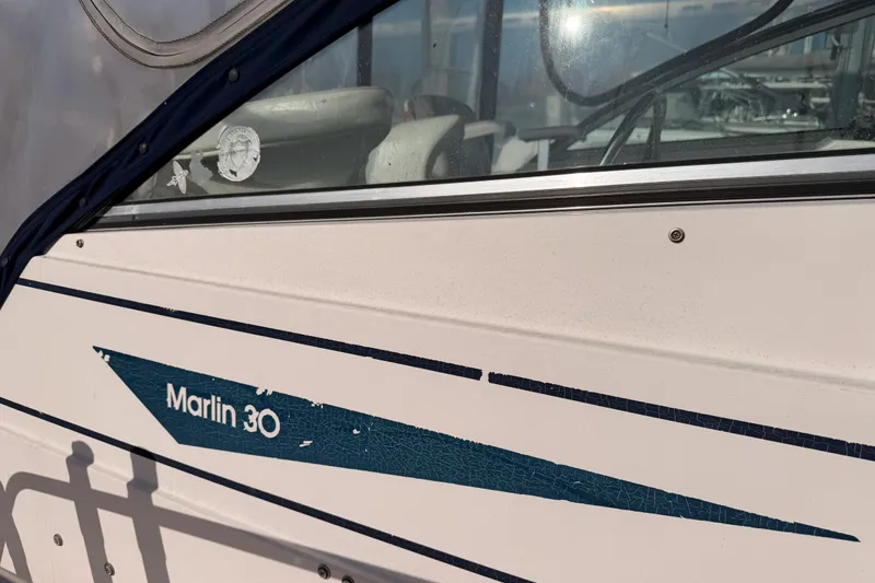 Slide: The Image of 1993 Grady-White Marlin 300 boat with visible logo and window details. - 36