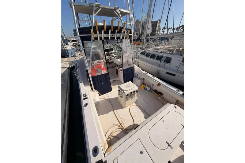 Slide: The Image of 1993 Grady-White Marlin 300 boat docked, featuring spacious deck and fishing rod holders. - 7