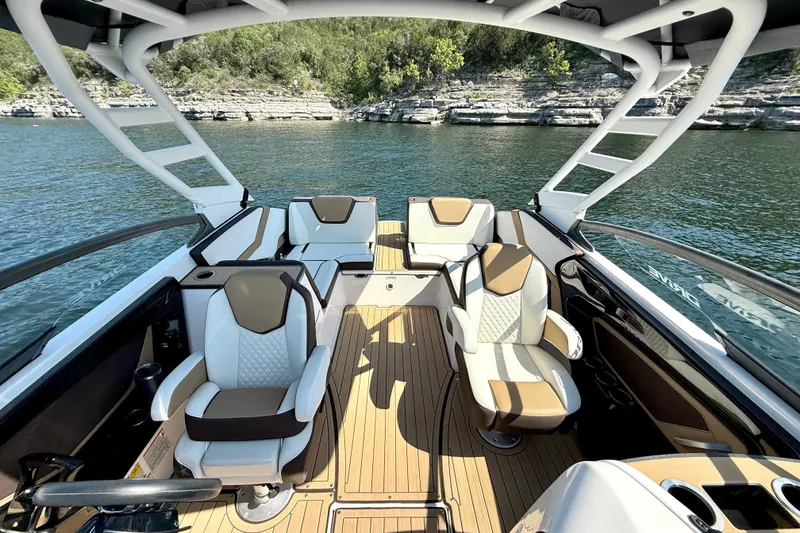 Slide: The Image of 2022 Yamaha Boats 252SD interior with luxurious seating on a scenic lake. - 15