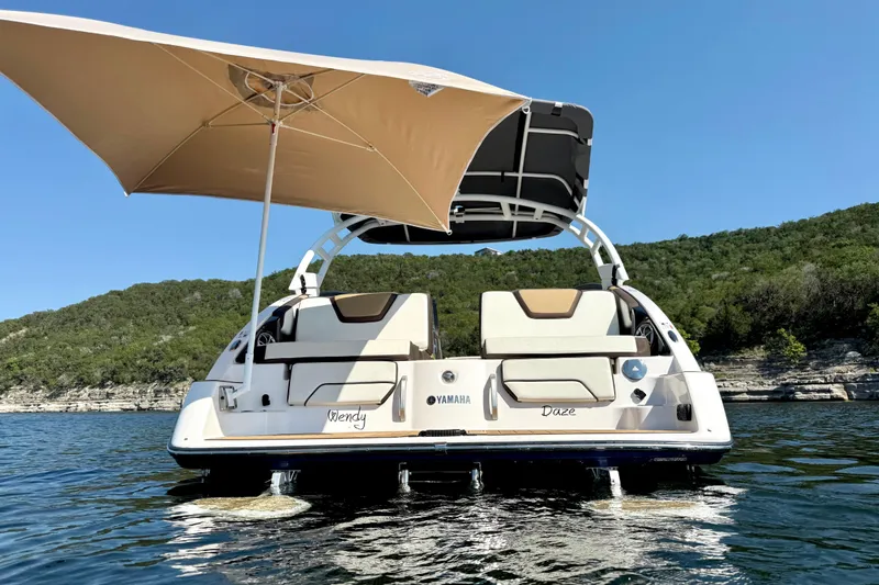 Slide: The Image of 2022 Yamaha Boats 252SD on water, featuring a sunshade and scenic backdrop. - 2