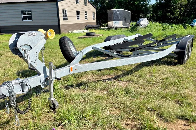 Slide: The Image of Boat trailer for 2022 Yamaha Boats 252SD on grassy field near building. - 25