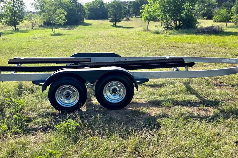 Slide: The Image of Trailer for 2022 Yamaha Boats 252SD on grassy field background. - 26