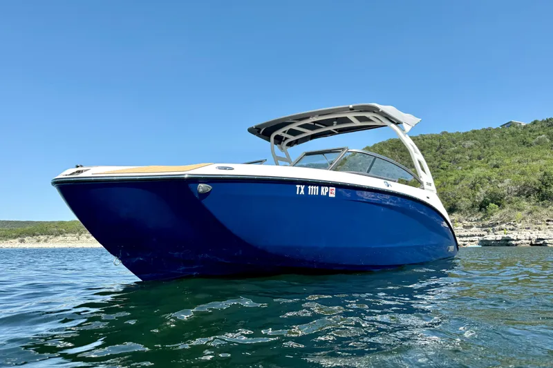 Slide: The Image of 2022 Yamaha Boats 252SD on water, blue hull, sunny day, scenic background. - 6