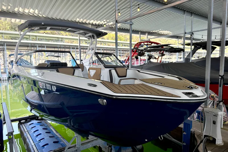 Slide: The Image of 2022 Yamaha Boats 252SD in marina, sleek design, blue hull, covered dock. - 8