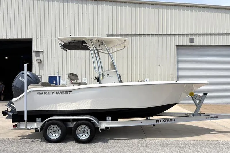 Slide: The Image of 2024 Key West 203 FS boat on trailer outside industrial building. - 1