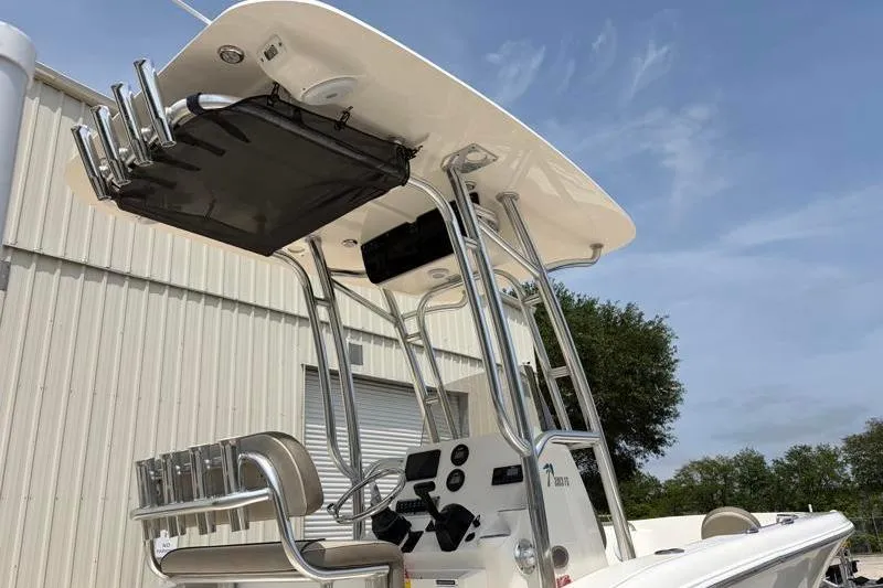 Slide: The Image of 2024 Key West 203 FS boat with T-top and rod holders, docked near a building. - 18