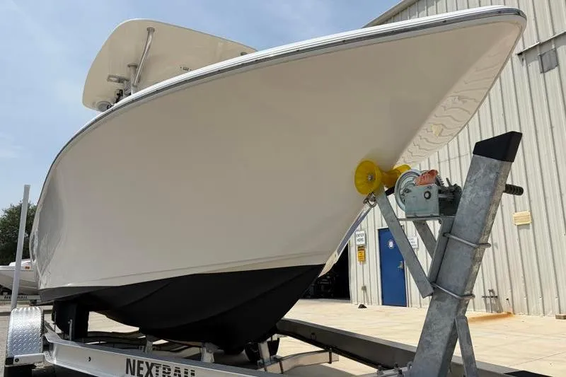 Slide: The Image of 2024 Key West 203 FS boat on trailer outside a metal building. - 10